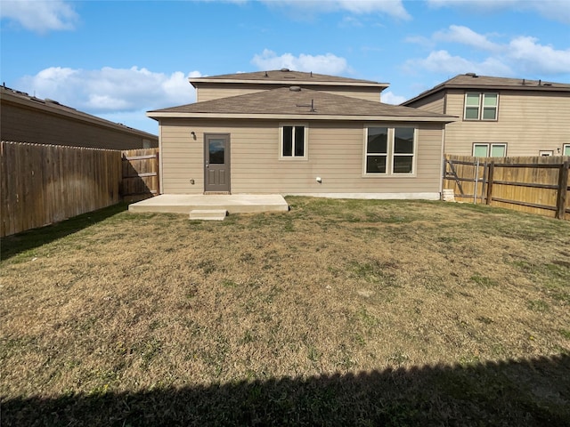 back of property with a lawn and a patio