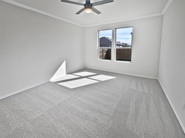 empty room featuring ceiling fan, carpet, and crown molding