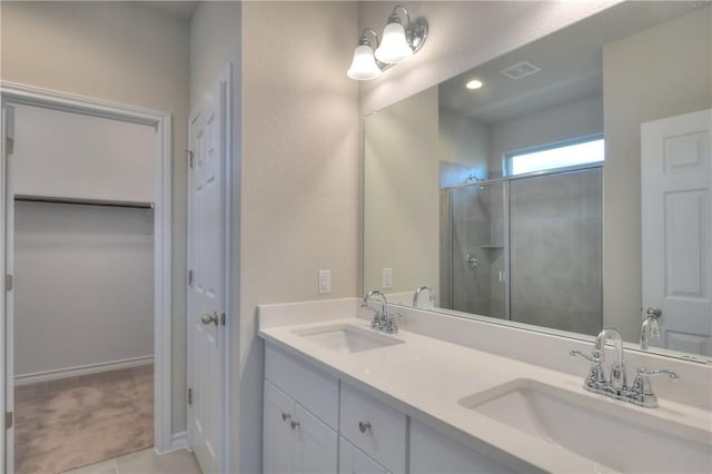 bathroom featuring tile patterned flooring, walk in shower, and vanity