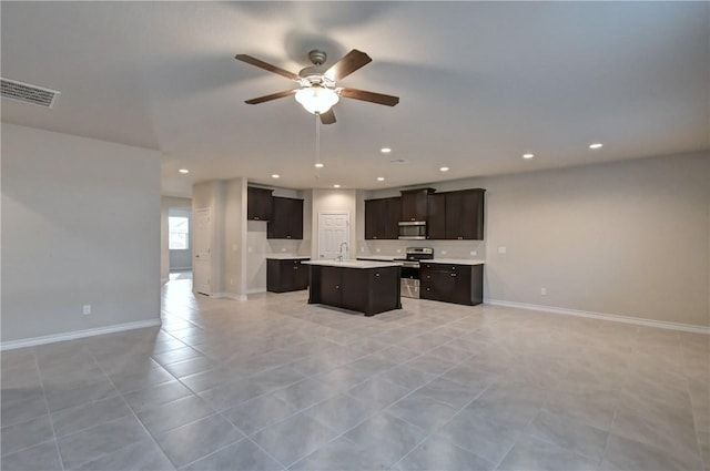 kitchen with a center island, stainless steel appliances, sink, ceiling fan, and light tile patterned floors