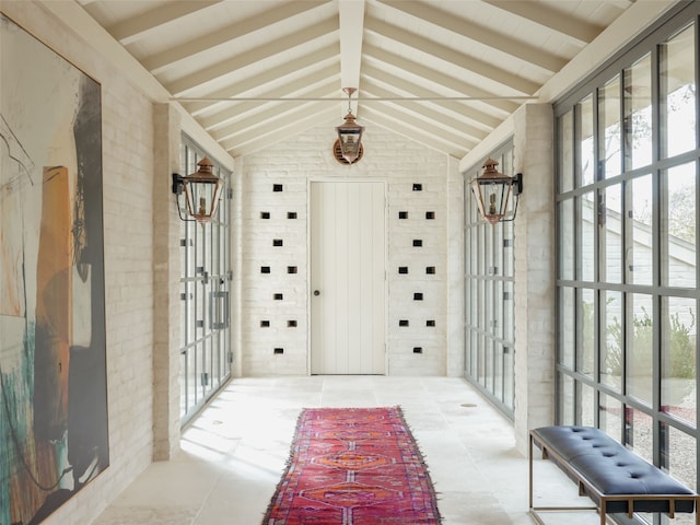 sunroom featuring vaulted ceiling with beams