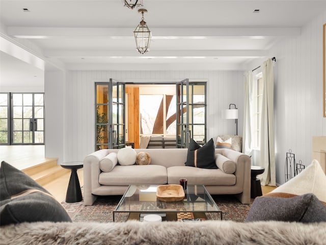 living room with dark hardwood / wood-style flooring, beamed ceiling, and wood walls