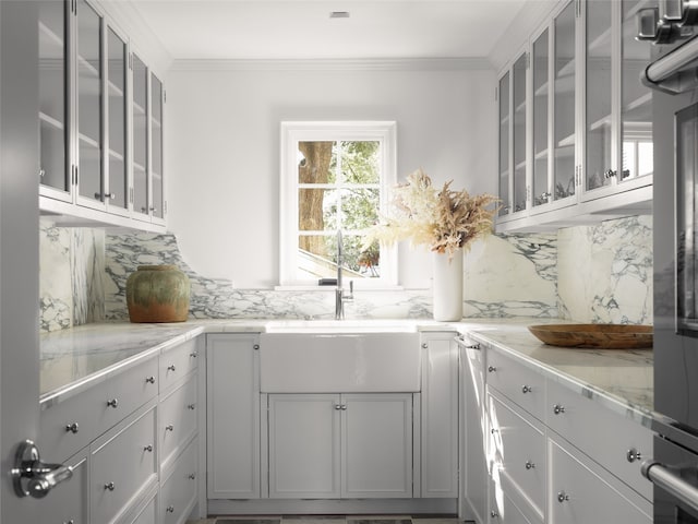 kitchen featuring white cabinetry, crown molding, and tasteful backsplash