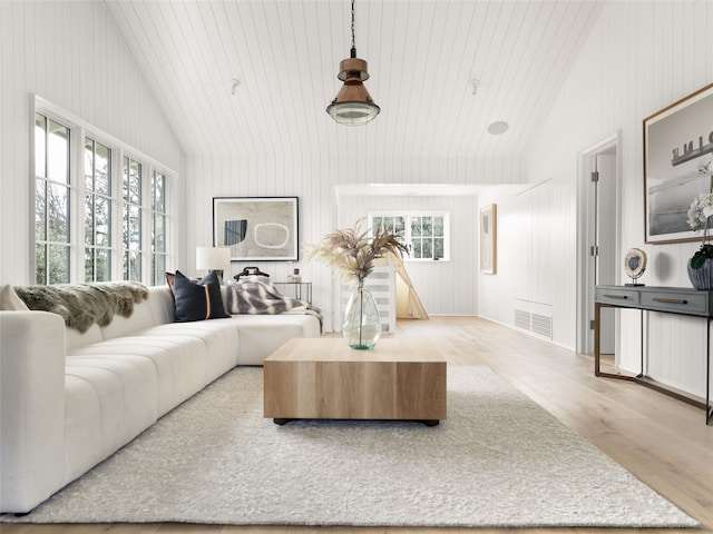 living room with wooden ceiling, vaulted ceiling, wood walls, and light hardwood / wood-style floors