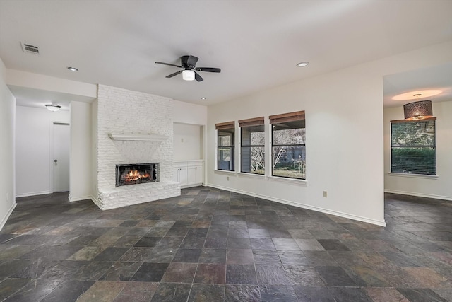 unfurnished living room featuring ceiling fan and a fireplace