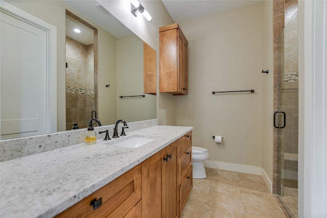 bathroom featuring toilet, tile patterned flooring, a shower with door, and vanity