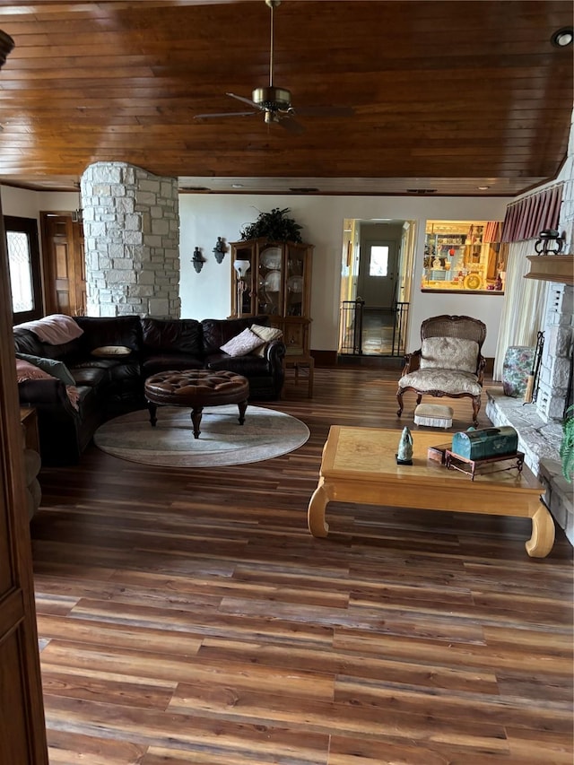 living room featuring a wealth of natural light, a fireplace, dark hardwood / wood-style flooring, and wooden ceiling