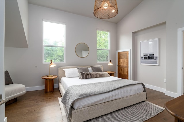 bedroom with dark hardwood / wood-style floors and lofted ceiling