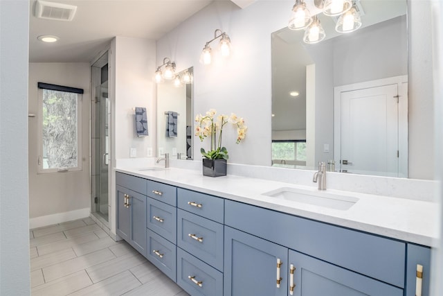 bathroom featuring tile patterned floors, vanity, and a shower with shower door