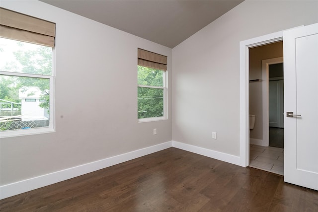 unfurnished bedroom featuring dark hardwood / wood-style floors and lofted ceiling