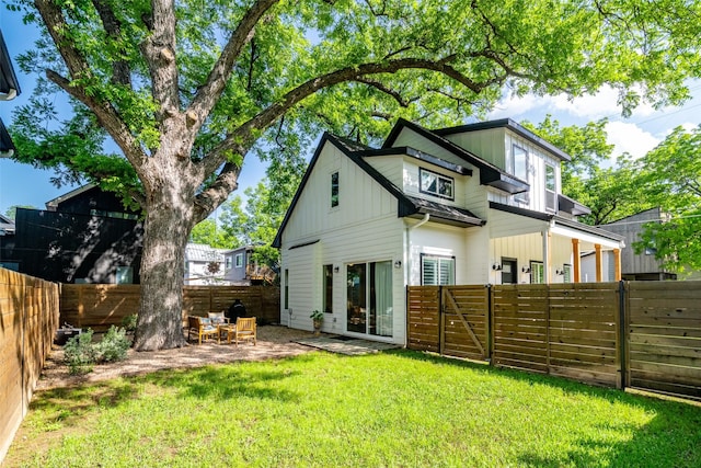 rear view of house with a lawn and a patio