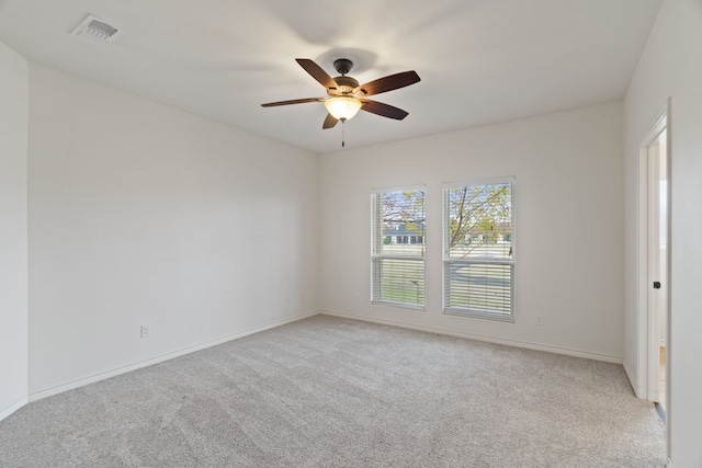 empty room featuring ceiling fan and light colored carpet