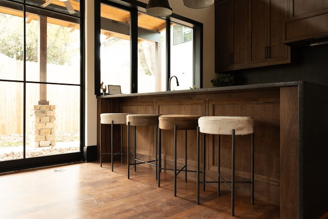 bar featuring wood-type flooring and sink