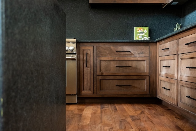 details with dark wood-type flooring and stainless steel range