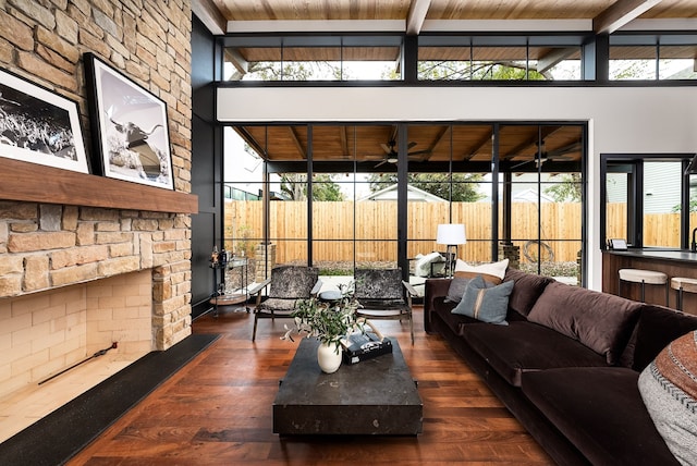 living room featuring plenty of natural light, beamed ceiling, dark hardwood / wood-style flooring, and wood ceiling