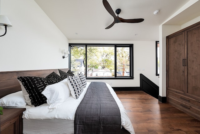 bedroom with ceiling fan, dark hardwood / wood-style floors, and lofted ceiling