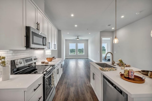 4507 E Martin Luther King Jr Blvd Unit 124, Austin, TX 78721 - kitchen featuring stainless steel appliances, a sink, dark wood-type flooring, tasteful backsplash, and a ceiling fan