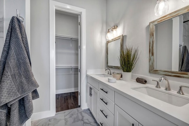 4507 E Martin Luther King Jr Blvd Unit 124, Austin, TX 78721 - bathroom featuring double vanity, marble look tiles, a walk in closet, and baseboards
