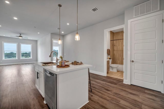 4507 E Martin Luther King Jr Blvd Unit 124, Austin, TX 78721 - kitchen featuring stainless steel dishwasher, a sink, dark wood finished floors, white cabinets, and baseboards