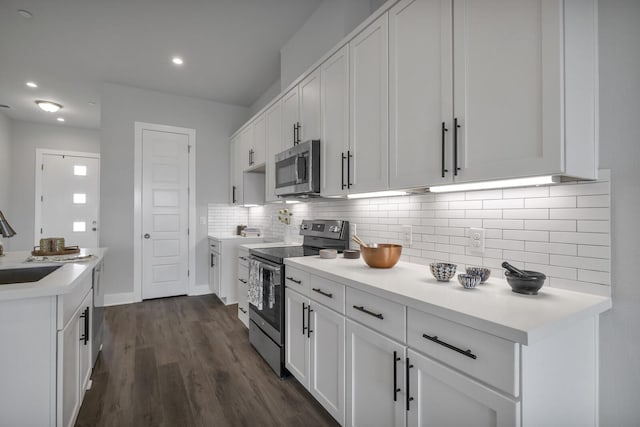 kitchen featuring white cabinetry, appliances with stainless steel finishes, backsplash, dark wood-type flooring, and sink