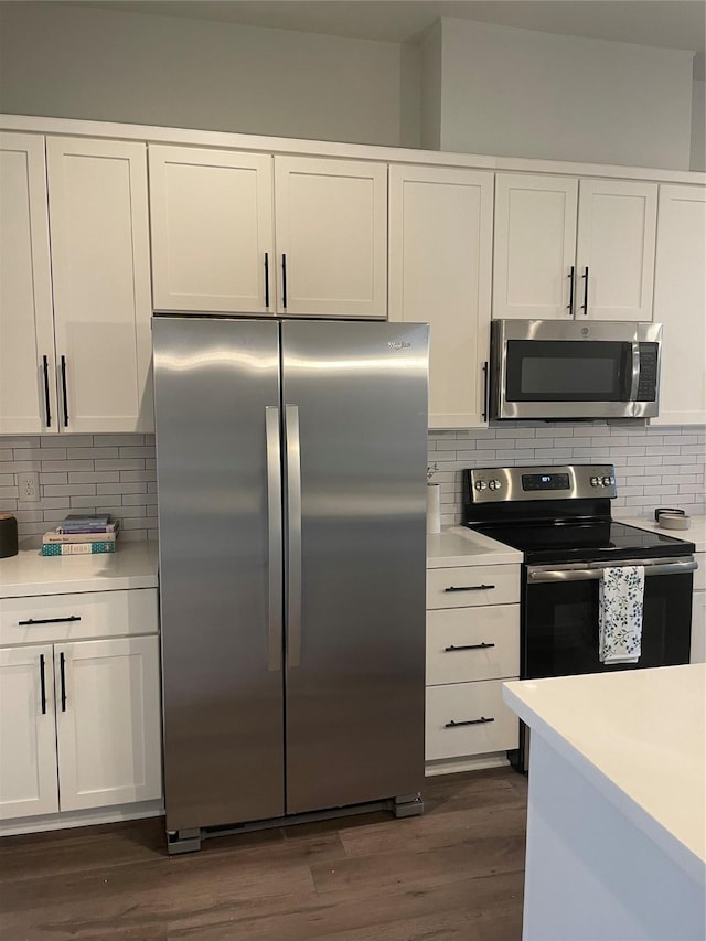 kitchen with decorative backsplash, white cabinets, dark hardwood / wood-style flooring, and stainless steel appliances