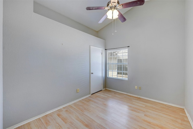 empty room with ceiling fan, light wood-type flooring, and high vaulted ceiling