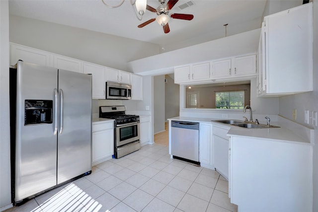 kitchen featuring ceiling fan, stainless steel appliances, vaulted ceiling, white cabinets, and sink