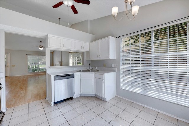 kitchen with ceiling fan with notable chandelier, white cabinets, sink, light tile patterned flooring, and stainless steel dishwasher