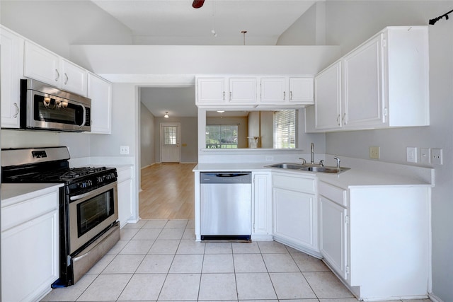 kitchen featuring light tile patterned floors, stainless steel appliances, white cabinets, and sink