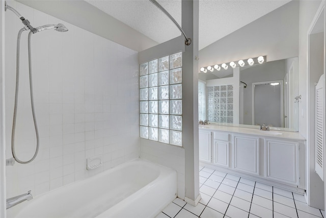 bathroom featuring vanity, tile patterned flooring, vaulted ceiling, tiled shower / bath combo, and a textured ceiling