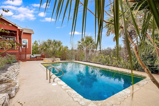 view of pool with a deck, a patio area, and an in ground hot tub