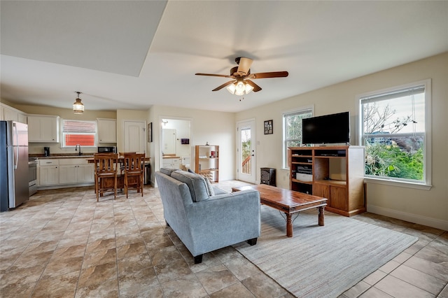 living room with ceiling fan and sink