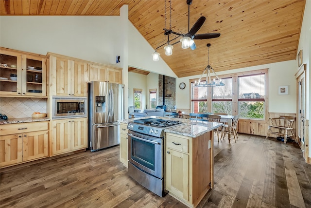 kitchen featuring hanging light fixtures, light stone countertops, stainless steel appliances, high vaulted ceiling, and dark hardwood / wood-style flooring