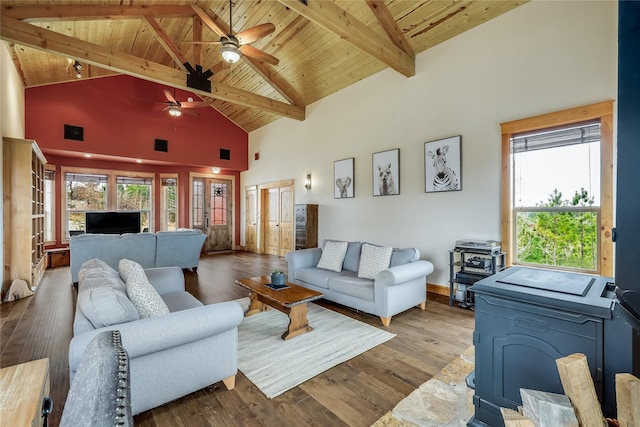 living room with wooden ceiling, ceiling fan, a wood stove, light wood-type flooring, and high vaulted ceiling