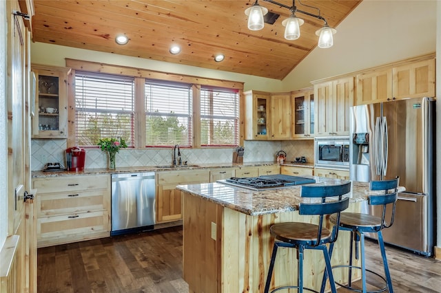 kitchen featuring tasteful backsplash, appliances with stainless steel finishes, hanging light fixtures, and a center island