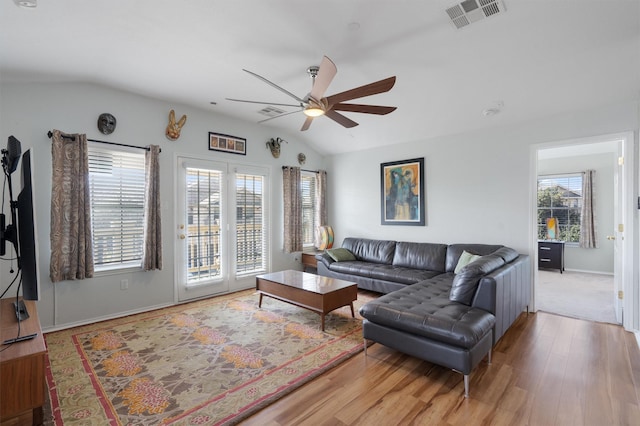 living room with hardwood / wood-style flooring, ceiling fan, lofted ceiling, and plenty of natural light