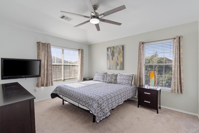bedroom featuring multiple windows, light colored carpet, baseboards, and a ceiling fan
