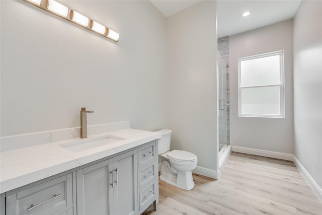 bathroom with a shower with door, wood-type flooring, toilet, and vanity