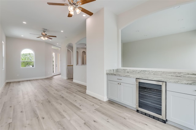 interior space featuring wine cooler, ceiling fan, and light hardwood / wood-style flooring