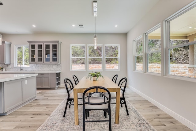 dining space with light hardwood / wood-style flooring, plenty of natural light, and sink