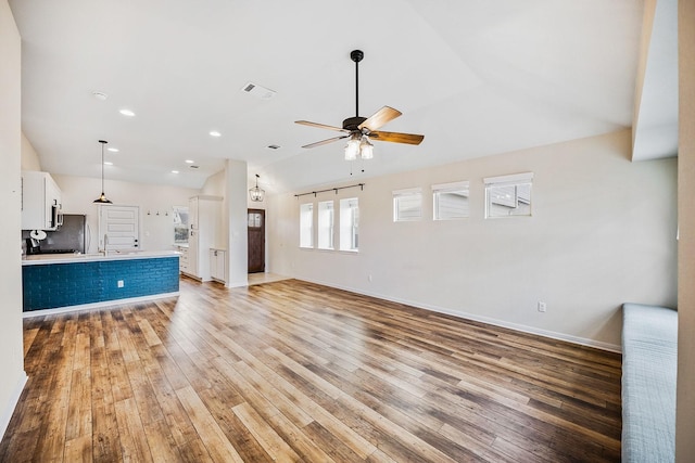 unfurnished living room featuring ceiling fan, lofted ceiling, and light hardwood / wood-style flooring