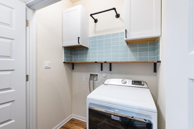 washroom with cabinets, hardwood / wood-style flooring, and washer / clothes dryer