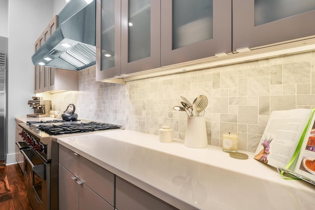 kitchen with range hood, dark wood-type flooring, backsplash, and high end range