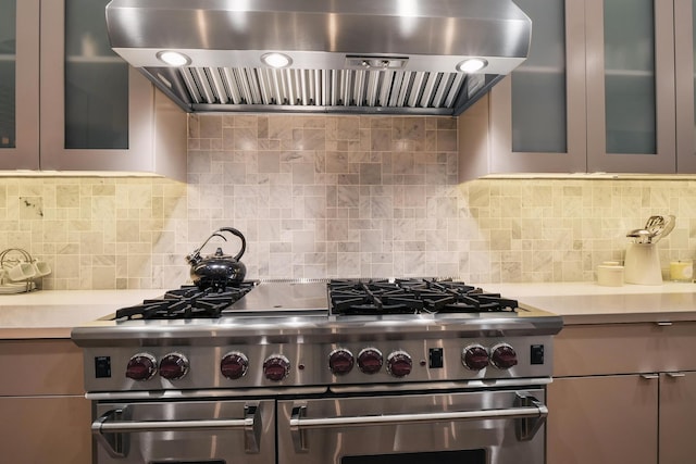 kitchen featuring ventilation hood, backsplash, and double oven range