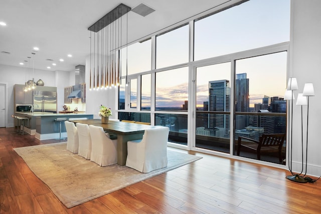 dining area featuring hardwood / wood-style floors and a wall of windows