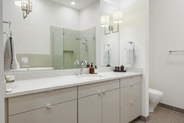 bathroom featuring toilet, vanity, and an enclosed shower