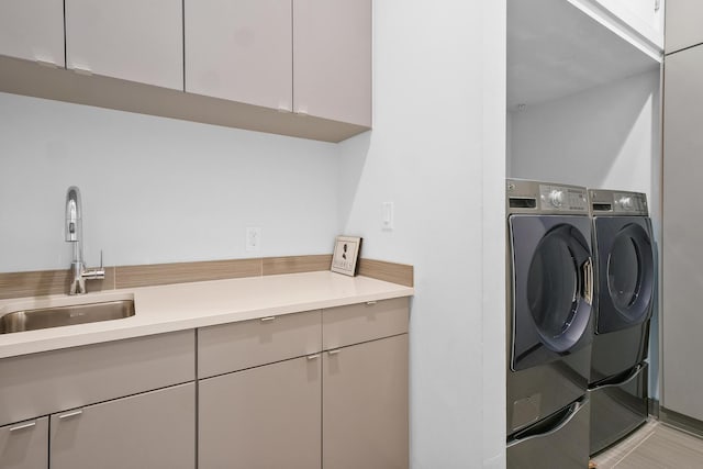 washroom with cabinets, sink, washer and clothes dryer, and light tile patterned flooring