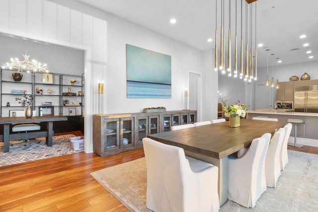 dining space with an inviting chandelier and light wood-type flooring