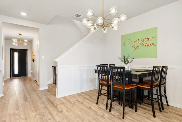 dining room featuring light hardwood / wood-style flooring and a notable chandelier