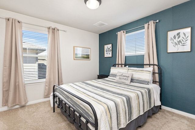 bedroom with light carpet and multiple windows